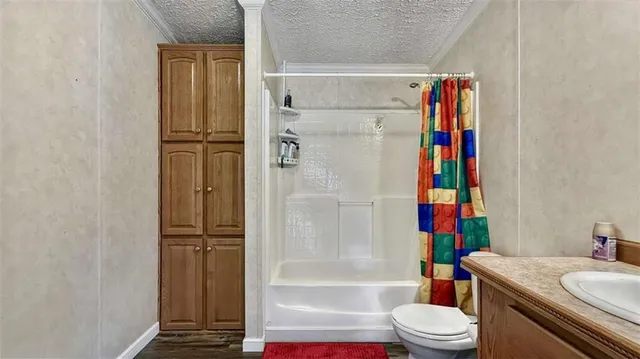 a bathroom with a granite countertop toilet a sink and a mirror