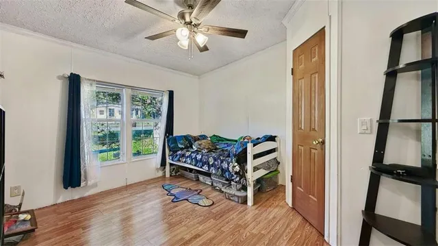 a bedroom with bed and wooden floor