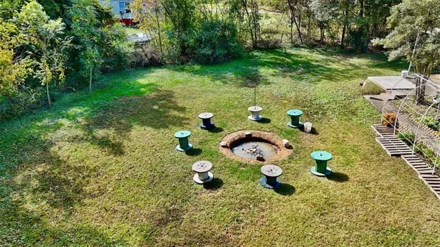 an aerial view of a house with a yard swimming pool and large trees