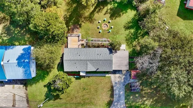 a front view of a house with a garden and trees