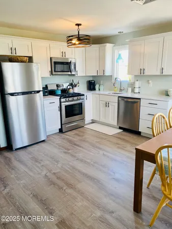 a kitchen with stainless steel appliances a stove a sink and a refrigerator