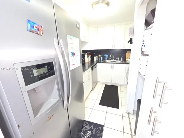 a hallway with painting on the wall and a potted plant