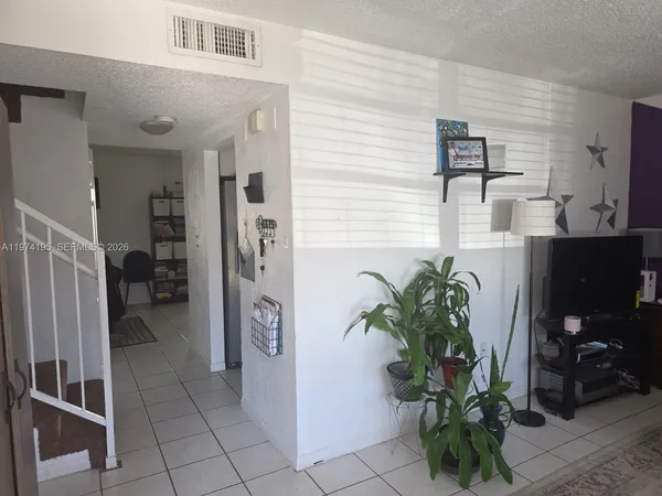 a bedroom with a large bed and a flat tv screen on dresser