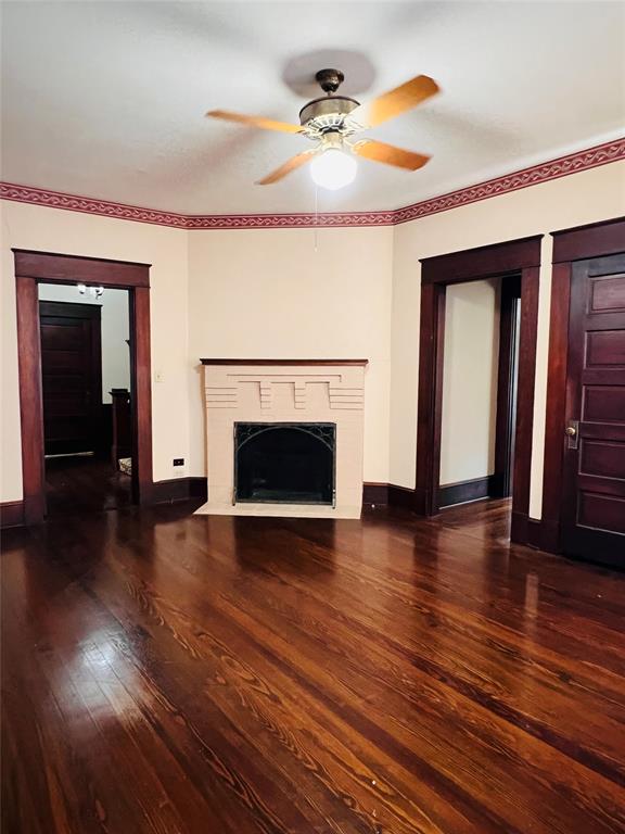 505 North Elm Street Comanche, TX 76442 - Photo 14 of 40 an empty room with wooden floor fireplace and windows