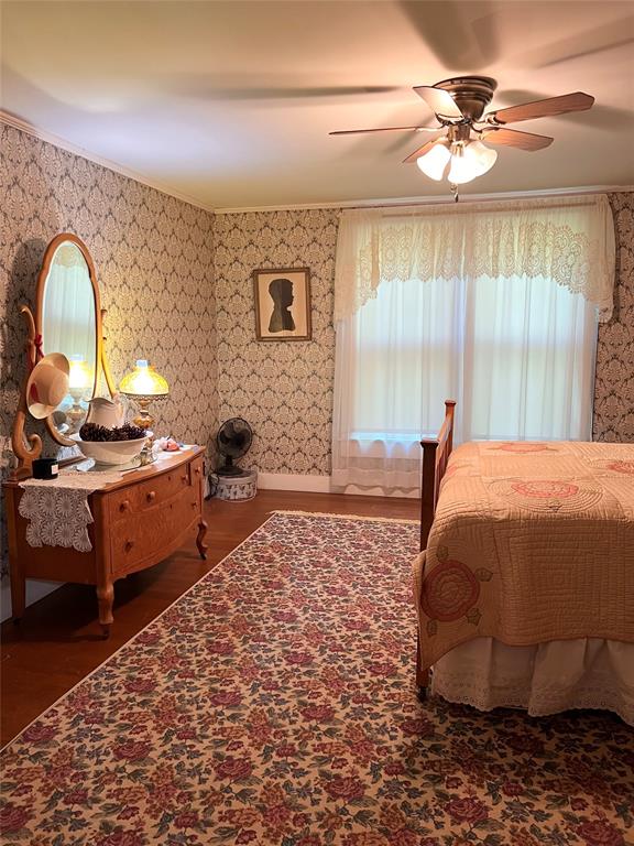 505 North Elm Street Comanche, TX 76442 - Photo 21 of 40 a bedroom with a bed dresser and a window