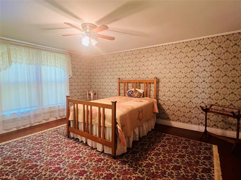 505 North Elm Street Comanche, TX 76442 - Photo 22 of 40 a bed sitting in a room next to a window