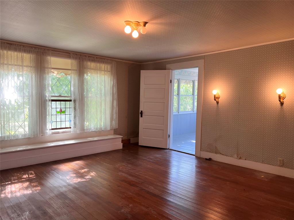 505 North Elm Street Comanche, TX 76442 - Photo 23 of 40 an empty room with wooden floor and windows