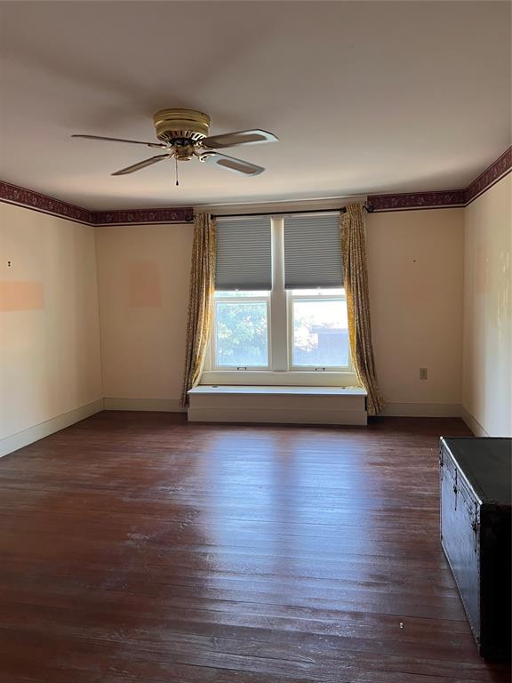 505 North Elm Street Comanche, TX 76442 - Photo 26 of 40 an empty room with wooden floor and windows