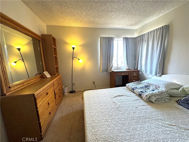 a bedroom with a bed and a flat tv screen on dresser