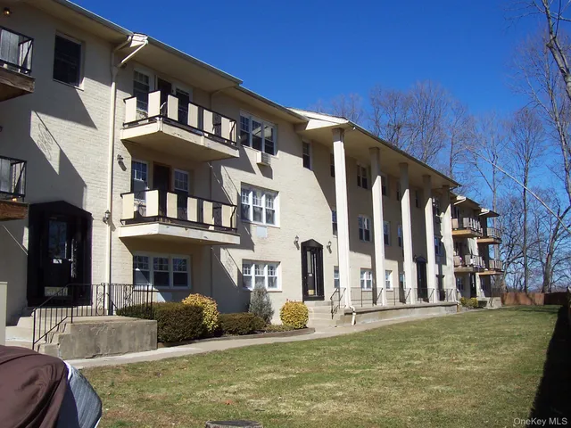 a front view of a building with a garden