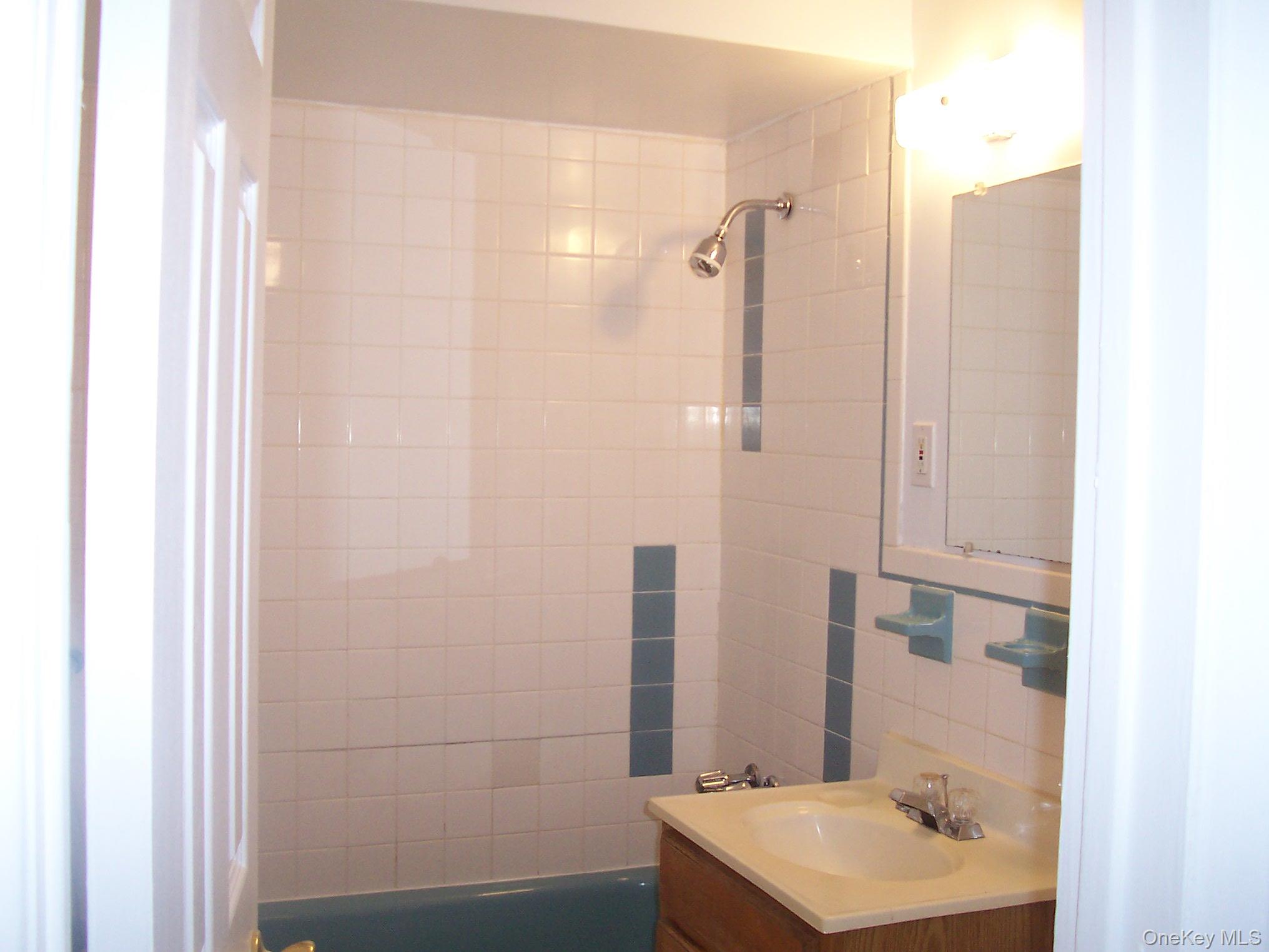 21 Pavilion Road, Unit 6 Suffern, NY 10901 - Photo 5 of 8 a bathroom with a sink a mirror and shower