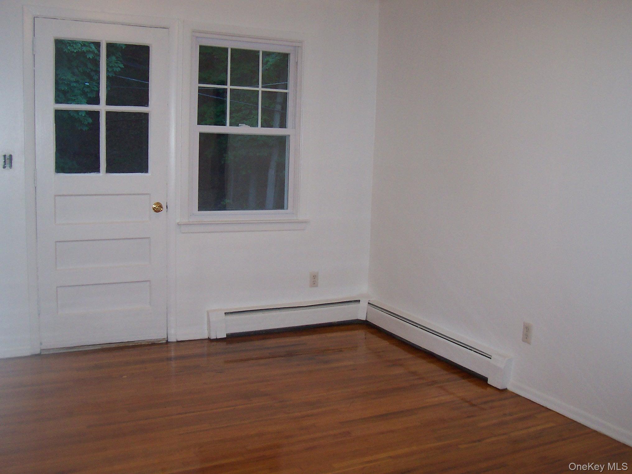 21 Pavilion Road, Unit 6 Suffern, NY 10901 - Photo 7 of 8 an empty room with wooden floor and windows