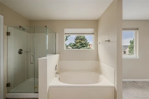 a white bath tub sitting next to a shower