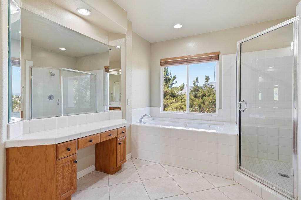 2612 Coyote Ridge Terrace Chula Vista, CA 91915 - Photo 40 of 57 a bathroom with a granite countertop sink a bathtub and a shower