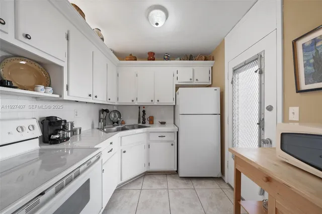 a kitchen with cabinets a refrigerator and a sink