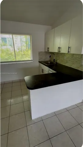 a kitchen with a sink a counter top space and cabinets