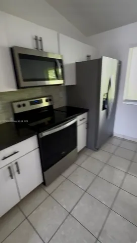a kitchen with granite countertop a stove and a microwave