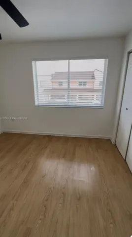 a view of a room with wooden floor and window
