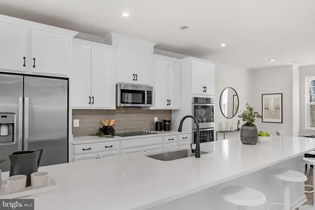 a kitchen with stainless steel appliances a sink a stove and a refrigerator