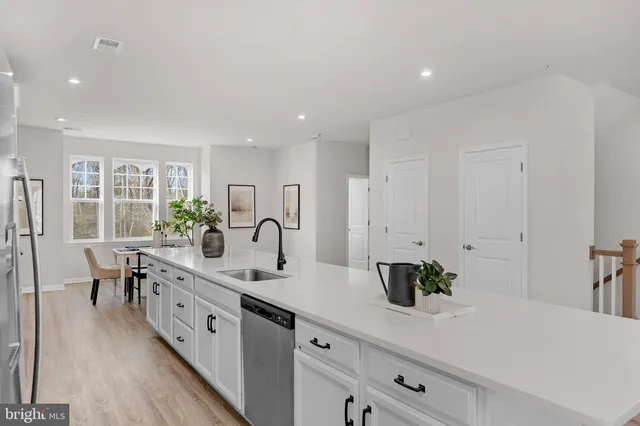 a large white kitchen with stainless steel appliances