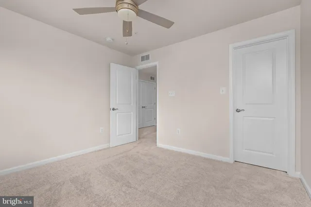 an empty room with chandelier fan