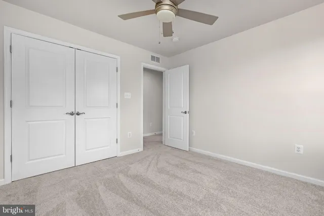 an empty room with a ceiling fan and a window