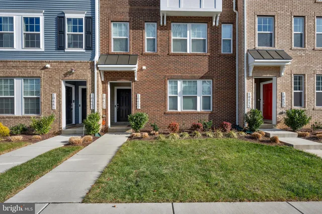 front view of a brick house with a yard