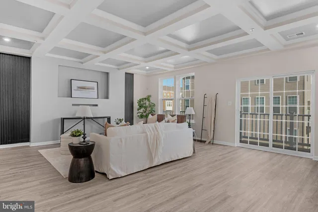 a living room with furniture a wooden floor and potted plant