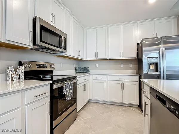 a kitchen with stainless steel appliances a sink stove cabinets and a refrigerator