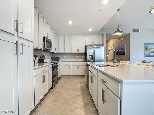 a kitchen with white cabinets and stainless steel appliances