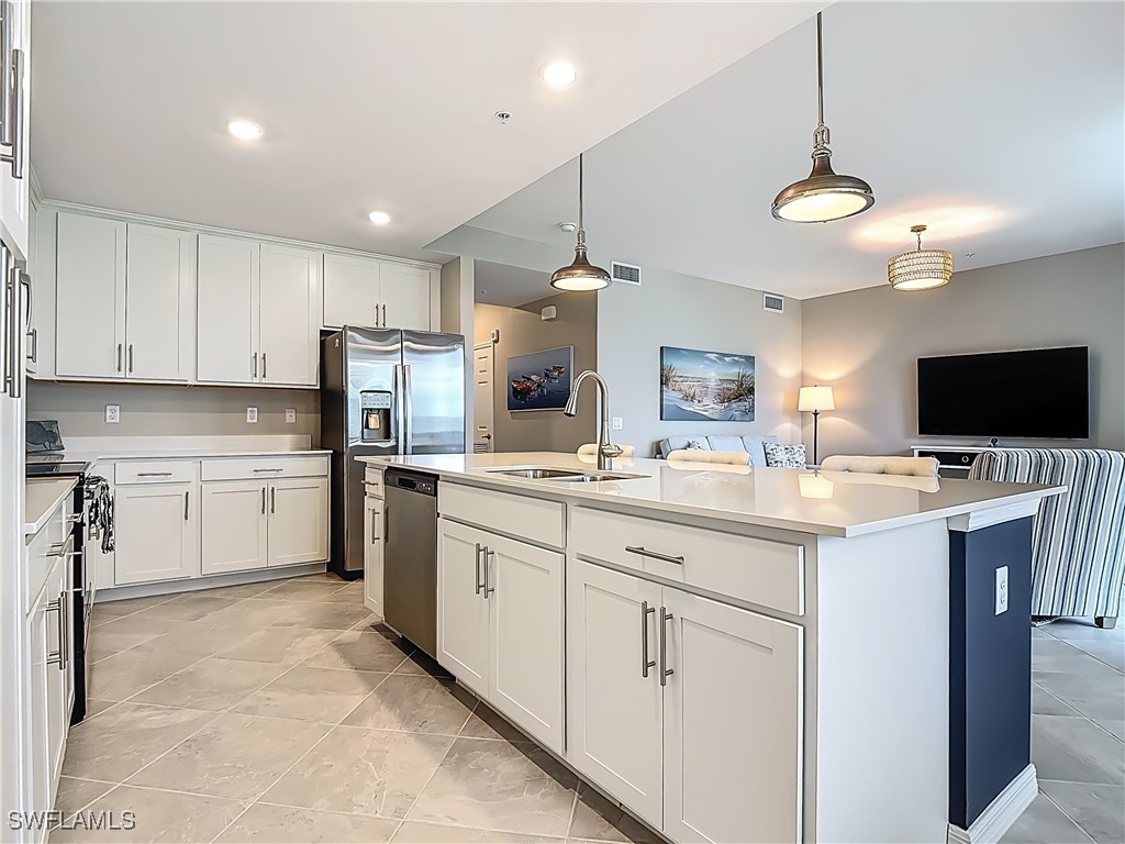 43981 Boardwalk Loop, Unit 2222 Punta Gorda, FL 33982 - Photo 13 of 50 a kitchen with white cabinets and stainless steel appliances