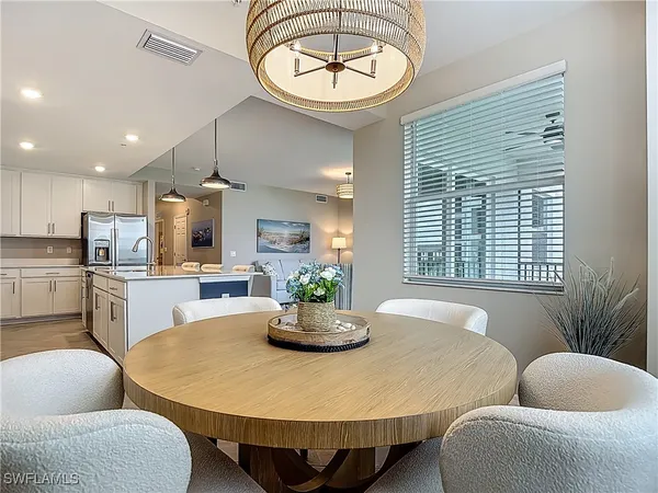 a dining room with furniture potted plants and a chandelier