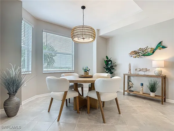 a kitchen with stainless steel appliances kitchen island granite countertop a dining table chairs refrigerator and microwave