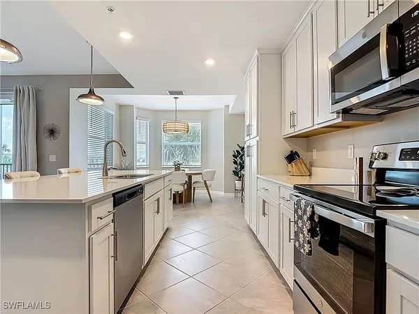 an open kitchen with a sink and chairs