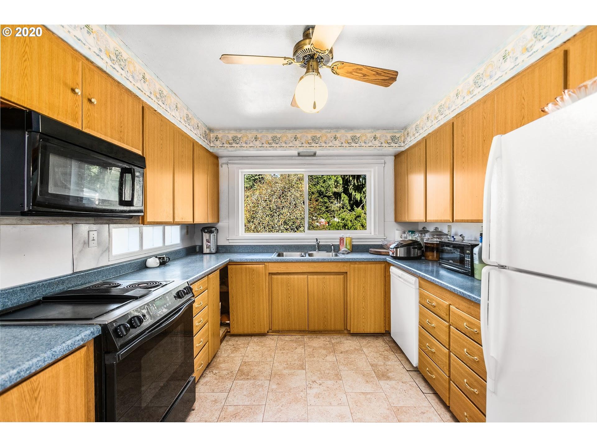 7110 Southwest Straughan Road Hillsboro, OR 97123 - Photo 9 of 28 a kitchen with stainless steel appliances granite countertop a stove a sink and a microwave