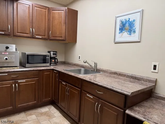 a kitchen with a sink cabinets and wooden floor