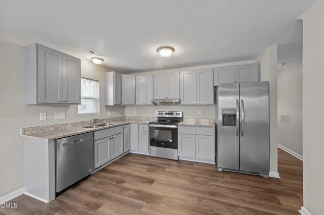 a kitchen with a stove top oven and refrigerator
