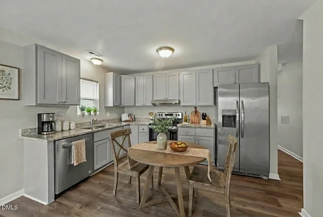 a kitchen with refrigerator cabinets dining table and chairs