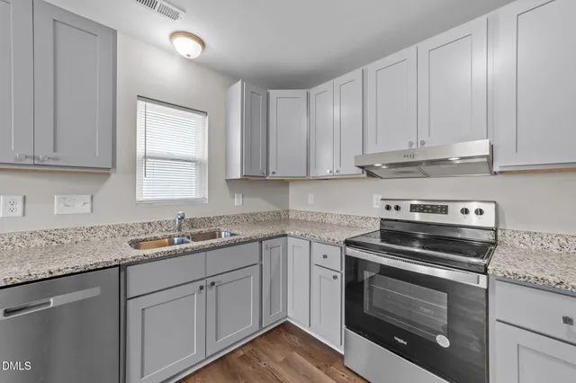 a kitchen with cabinets appliances a sink and a counter top