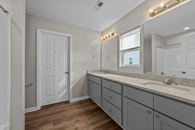 a bathroom with double vanity sink and a mirror