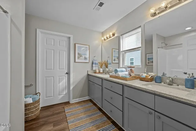 a bathroom with double vanity sinks and a mirror
