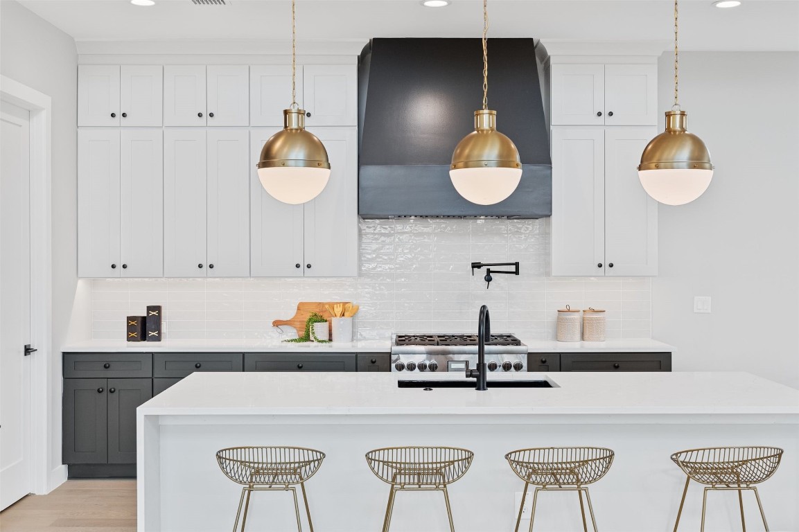 a kitchen with stainless steel appliances sinks a table and cabinets