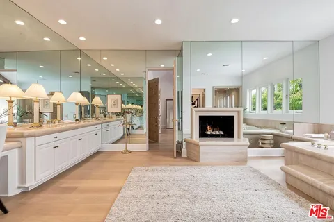 a spacious bathroom with a double vanity sink a large mirror and a shower