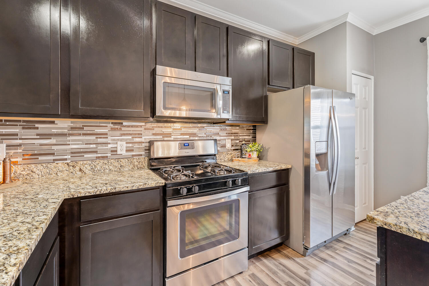 2725 West 127th Lane Crown Point, IN 46307 - Photo 15 of 51 a kitchen with granite countertop cabinets stainless steel appliances and wooden floor