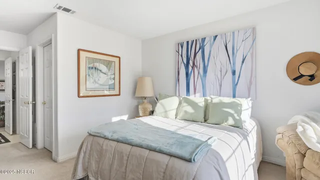 a bedroom with a bed and a painting on the wall