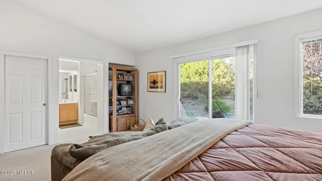 a bedroom with a large bed and a window