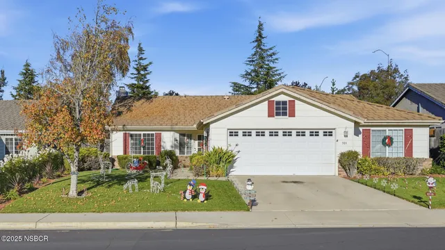 a view of front of house with a yard and potted plants