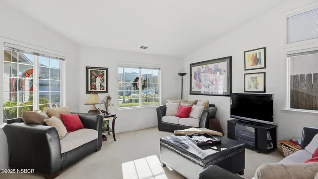 a living room with furniture a flat screen tv and a window