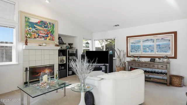 a living room with furniture a flat screen tv and a fireplace