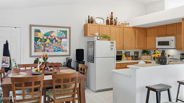 a dining table chairs and a refrigerator in a kitchen